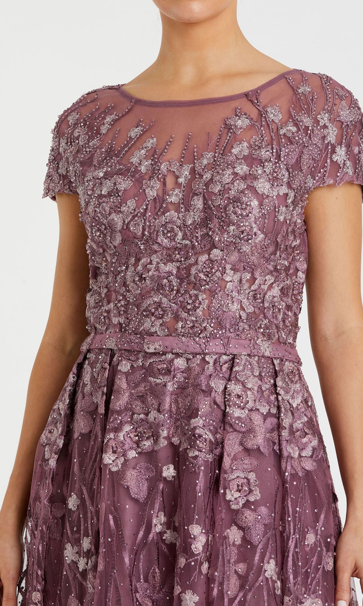 Wearing the Mac Duggal 20405, a short-sleeve long formal dress in mauve with embroidered lace, sheer cap sleeves, and intricate floral beadwork on the bodice and skirt.